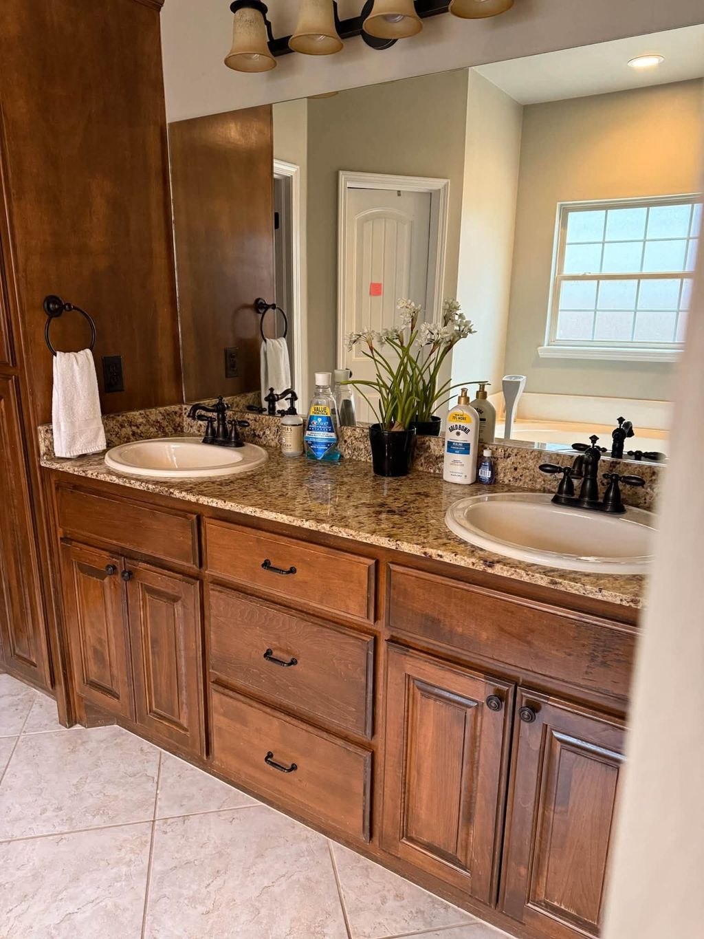 Bathroom double vanity with granite counter, two sinks and a wide mirror