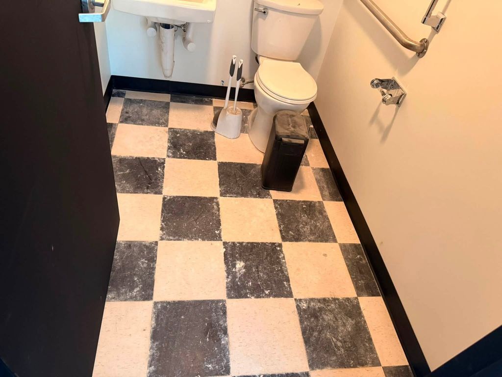 Black and white checkered bathroom floor before cleaning