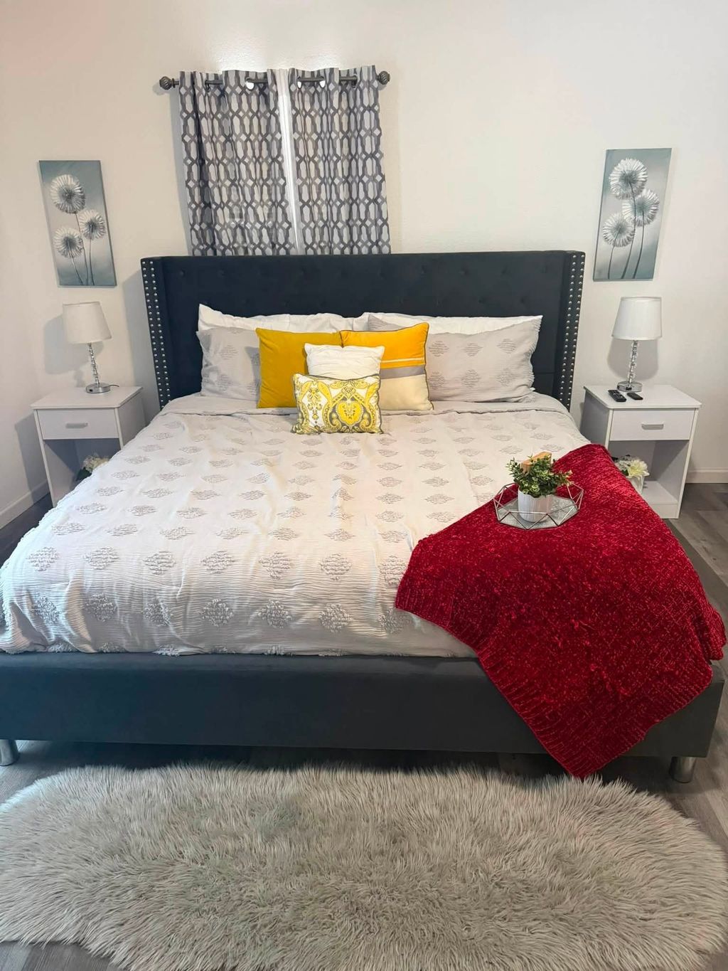 Neatly made bed with white bedding and arranged pillows
