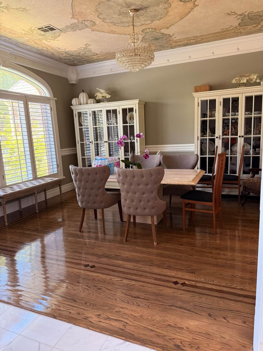 Dining room with polished hardwood floor, dining table and display cabinets