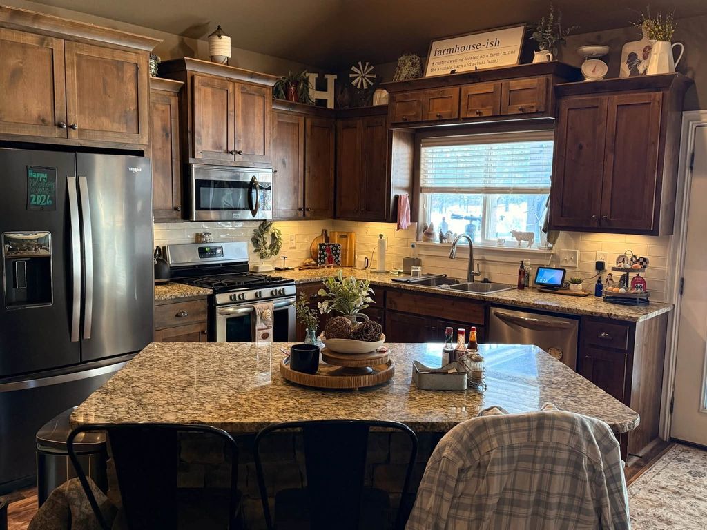 Clean kitchen with granite island and stainless steel appliances