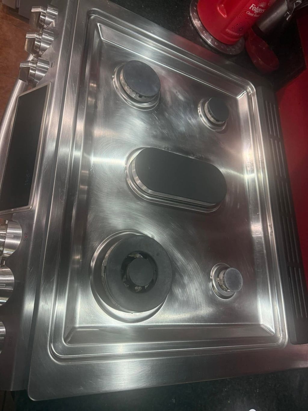 Stainless steel stovetop after cleaning with burners and surface polished