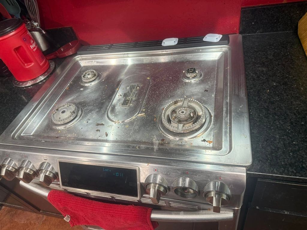 Stainless steel stovetop before cleaning with grease and food debris